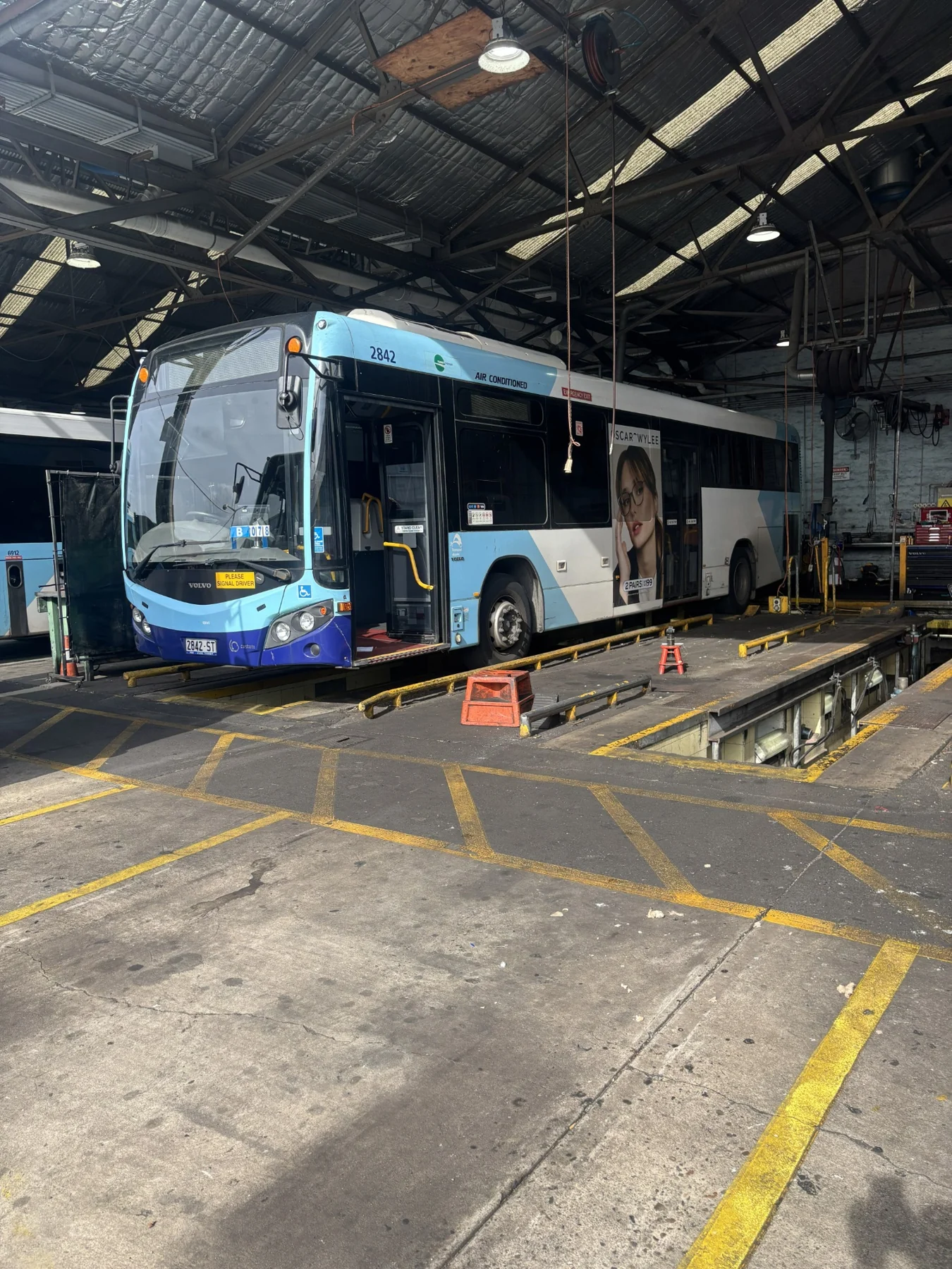 Bus positioned over a maintenance pit at a depot